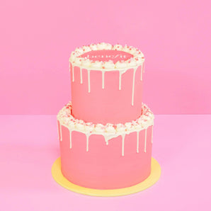 2 Tier Corporate Drip Cake with logo in pink with white drip icing and an edible logo plaque on top by Crumbs & Doilies.